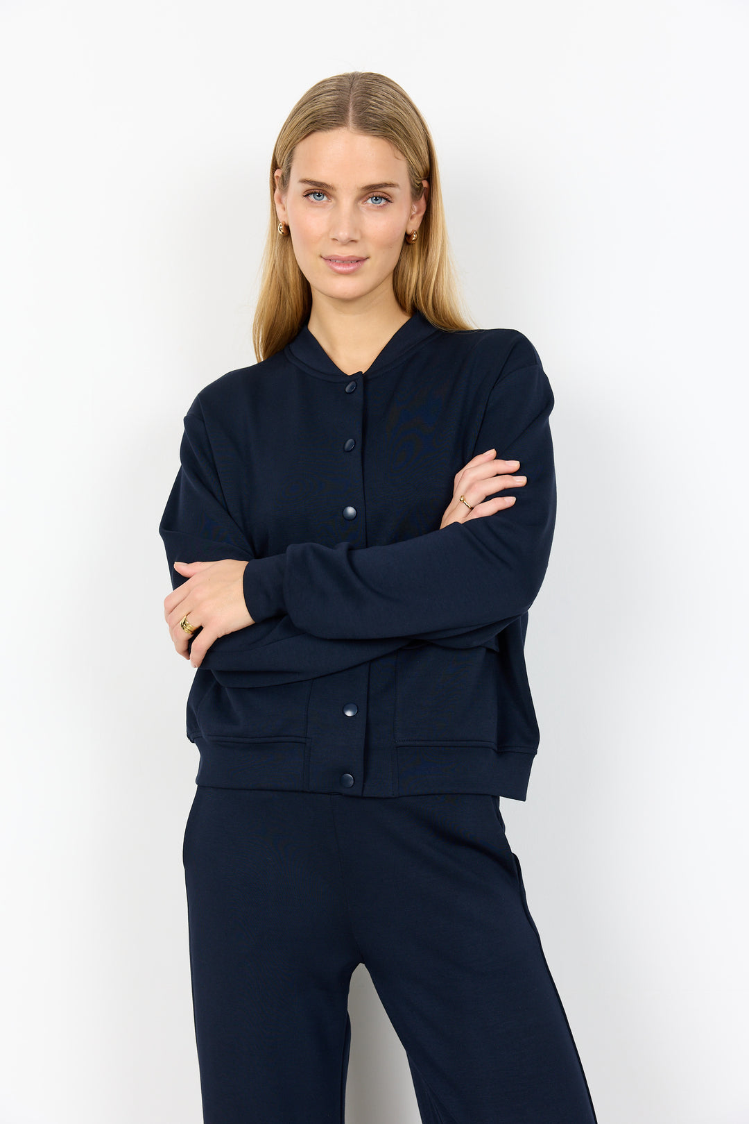 Woman wearing a navy blue outfit against a white background